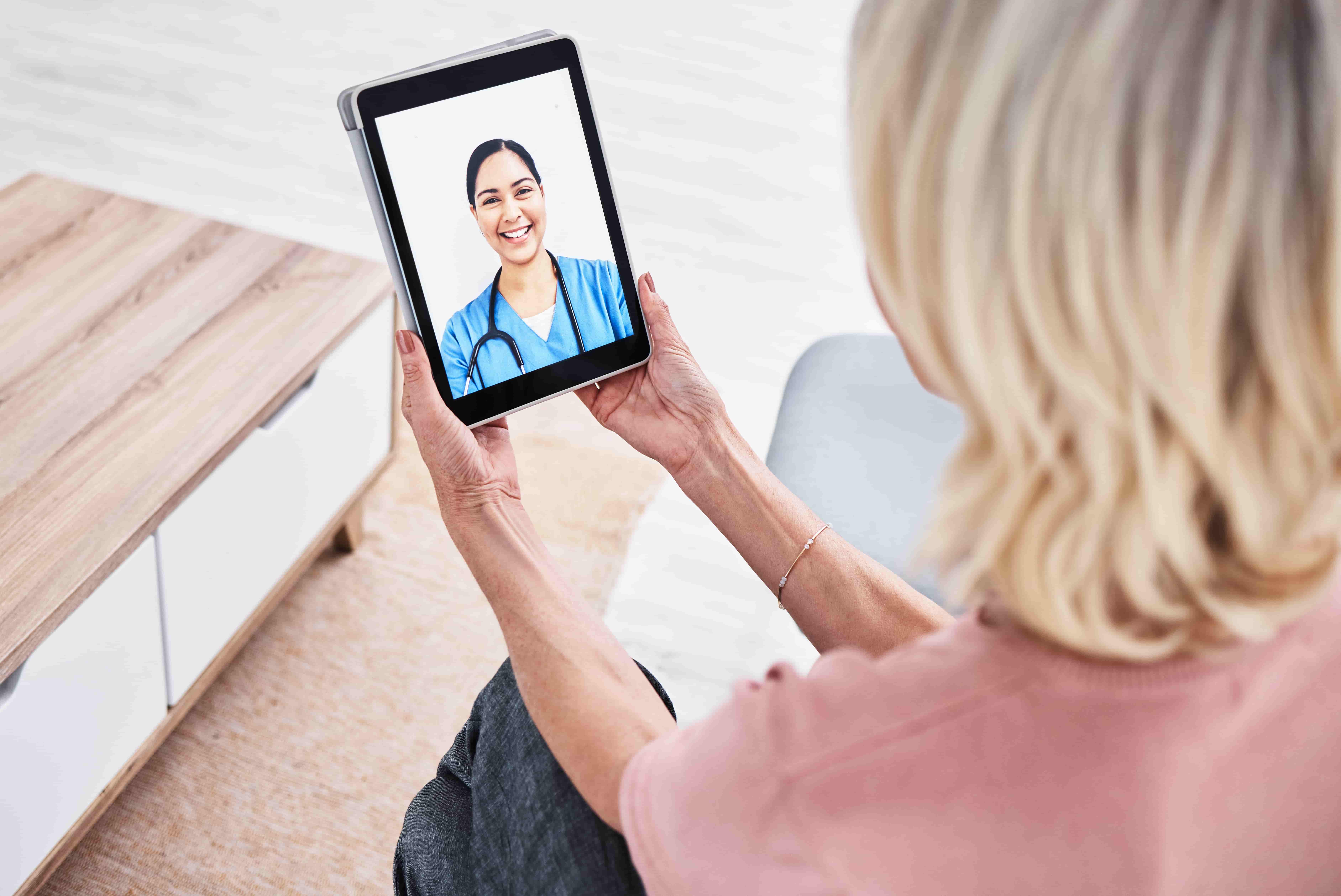Doctor using a stethoscope to examine a virtual heart, with holographic technology displaying heart health and an electrocardiogram waveform, representing medical technology and cardiovascular health.